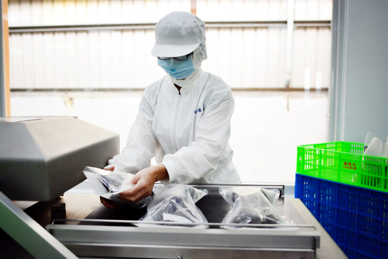 ▲憨兒進行粽子包裝。(圖/喜憨兒基金會提供)