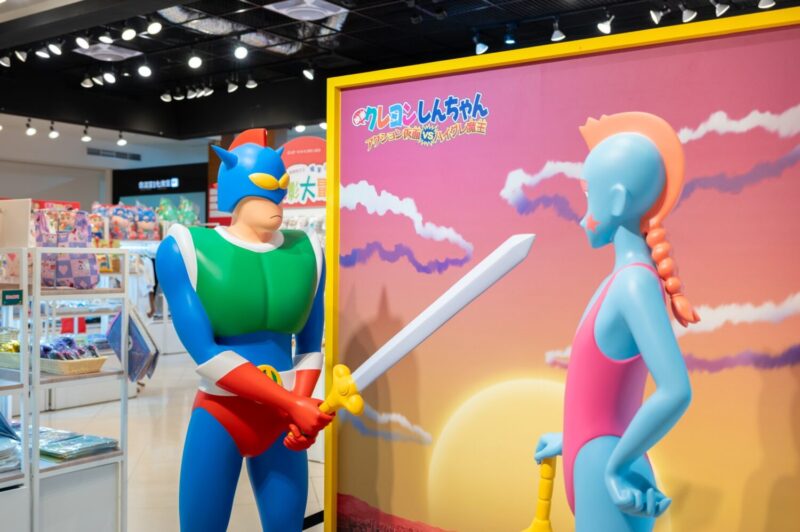 ▲展場延續32部歷年劇場版為主軸，打造沉浸式體驗動線，搭配等身公仔拍照區，重現《動感超人與高衩魔王》《搞怪樂園大冒險》等經典橋段。（圖/高雄夢時代提供）