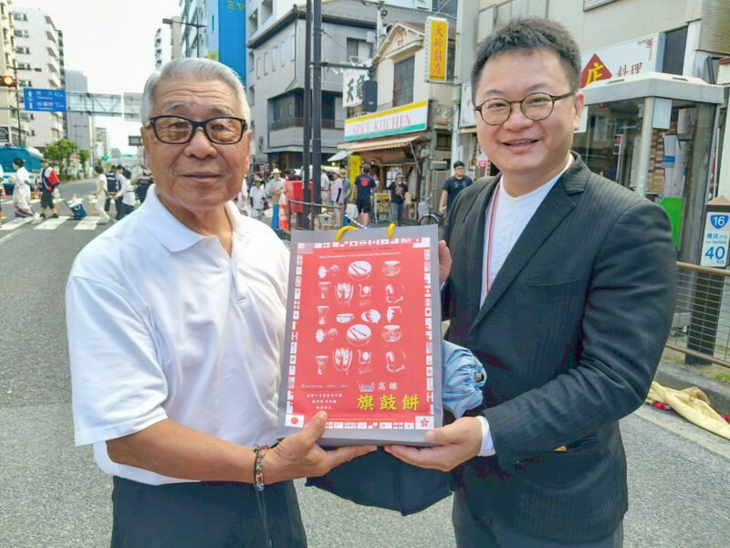 ▲中華藝校盧昰余(右)校長贈送高雄「旗鼓餅」給八王子市前市長「黑須隆一」。(圖/中華藝術學校提供)
