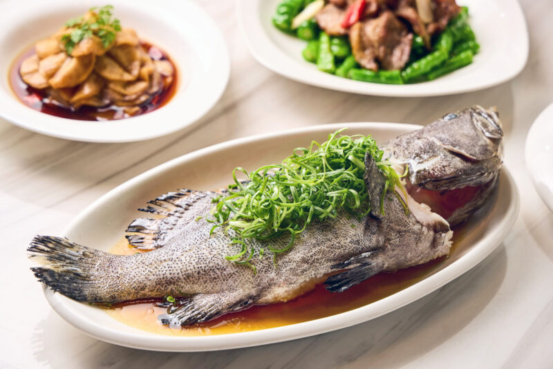 ▲「青絲玉露龍虎斑」選用當季鮮活龍虎斑現點現煮，魚肉細緻滑嫩，與翠綠蔥絲交織出清鮮雅致的海味。（圖/高雄萬豪酒店提供）