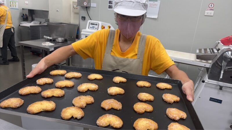 ▲憨兒展示烤好的餅乾。（圖/喜憨兒基金會提供）