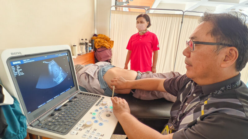 ▲阮綜合醫院醫師蕭偉成,很仔細為民眾做腹部超音波檢查。(記者張忠義攝)