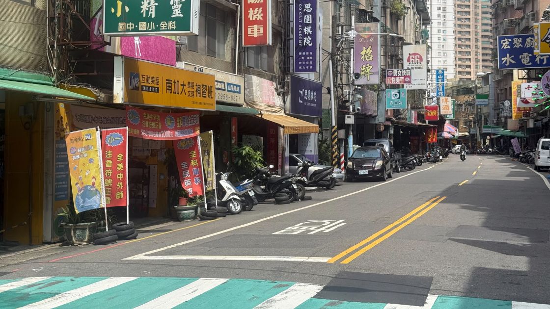 板橋海山里長安街138巷街景，路旁補習班招牌林立，路邊停滿機車與汽車