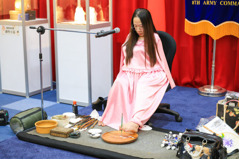 ▲楊恩典在現場以「腳」揮毫作畫，展現堅毅生命力與藝術才華，令眾人深受感動。（圖/陸軍八軍團提供）